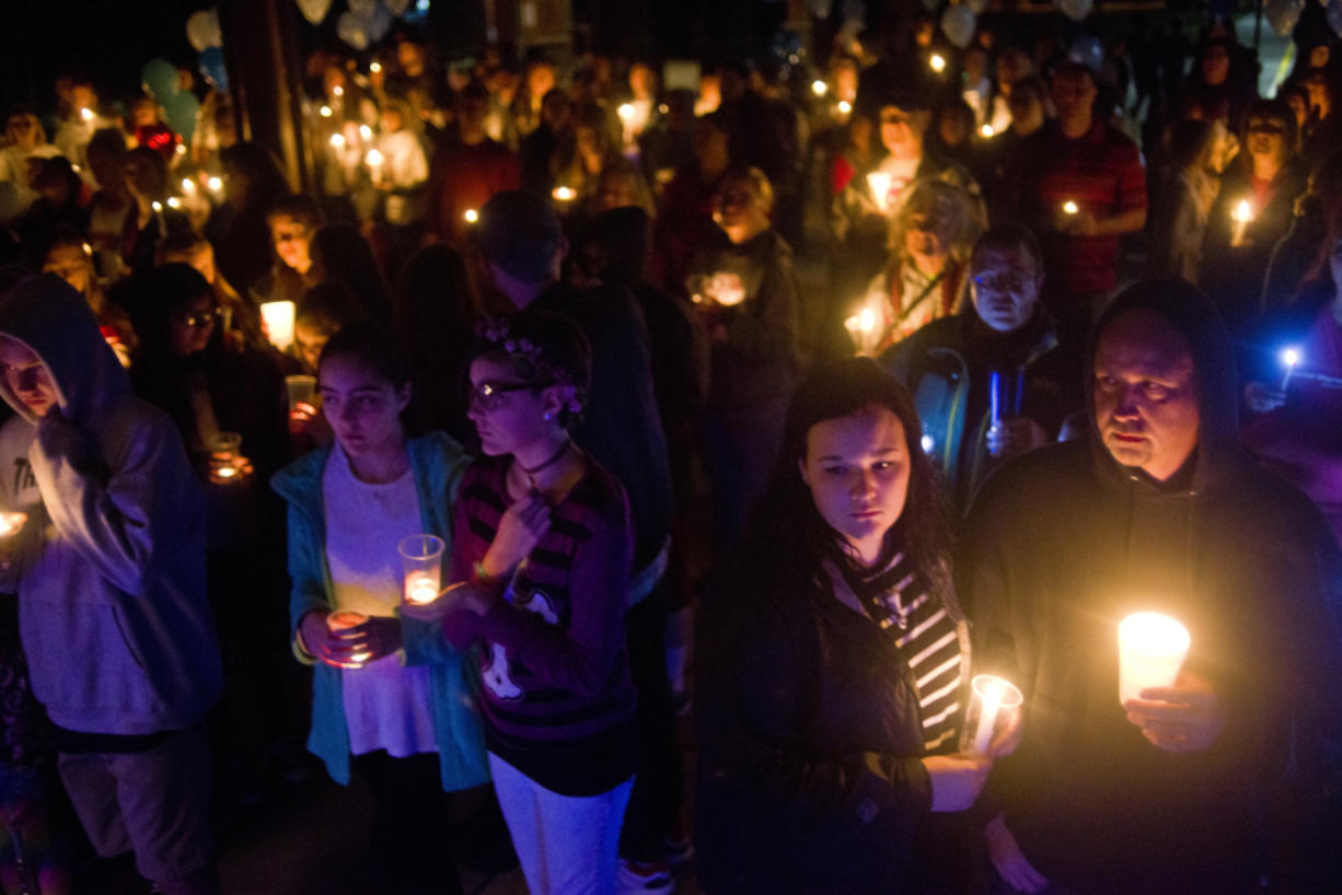 People gather to remember Elizabeth Smith, 11, during a candlelight vigil Sunday night at Daybreak Middle School in Battle Ground. She was killed after being struck by a minivan last week while waiting for her school bus.