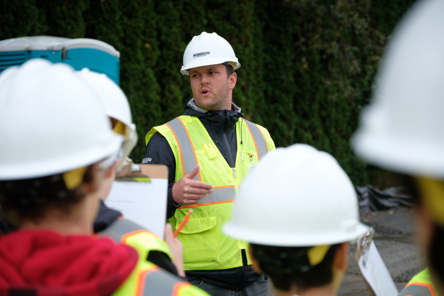Robinson Construction Project Manager Bryan Kenney, center, talks to Hockinson Middle School students before a tour of the construction site of the future middle school.