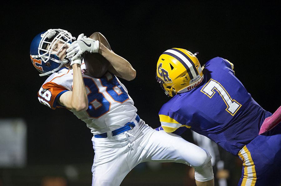 Ridgefield&#039;s Conner Bell (88) catches a pass in front of Columbia River defender Nathan Kunz (7) in the third quarter at Kiggins Bowl on Thursday night, Oct. 27, 2016.