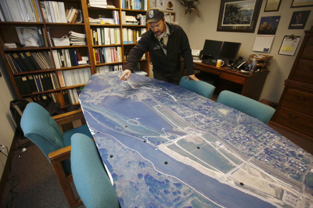 Chris Lapp of the U.S. Fish and Wildlife Service, the project leader at the Ridgefield National Wildlife Refuge, spreads out a big map in his office that shows the Port of Ridgefield (at bottom) and the Carty Unit of the Refuge (above). The Port has built trails across its property; the Refuge will build new ones to meet them. The result will be a miles-long seasonal walking loop.