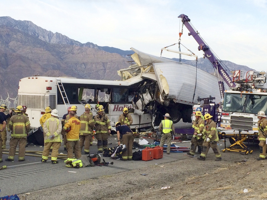 Emergency personnel work the scene where a tour bus crashed into the rear of a semi-truck on westbound Interstate 10, just north of the desert resort town of Palm Springs, in Desert Hot Springs, Calif., Sunday, Oct. 23, 2016. Multiple deaths and injuries were reported.