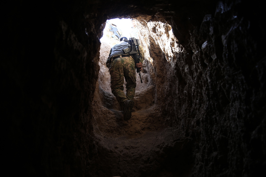 A peshmerga fighter walks through a tunnel made by Islamic State fighters Tuesday in the town of Badana, which was liberated from the Islamic State group on Monday. The fighters built tunnels under residential areas so they could move without being seen from above to avoid airstrikes.