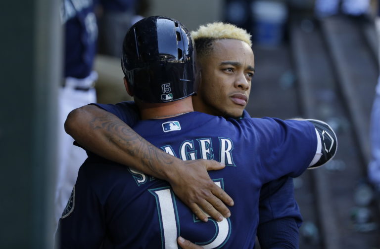 Seattle Mariners' Ketel Marte, right, hugs teammate Kyle Seager after Seager lined out in the ninth inning of a baseball game against the Oakland Athletics, Sunday, Oct. 2, 2016, in Seattle. (AP Photo/Ted S.