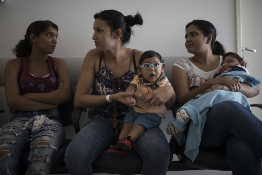 Babies born with  microcephaly Alexandro Julio, center, and Pedro Henrique, wait for their physical therapy session at the UPAE hospital in Caruaru, Pernambuco state, Brazil. A year after a spike in the number of newborns with the defect known as microcephaly, doctors and researchers have seen many of the babies develop swallowing difficulties, epileptic seizures and vision and hearing problems.