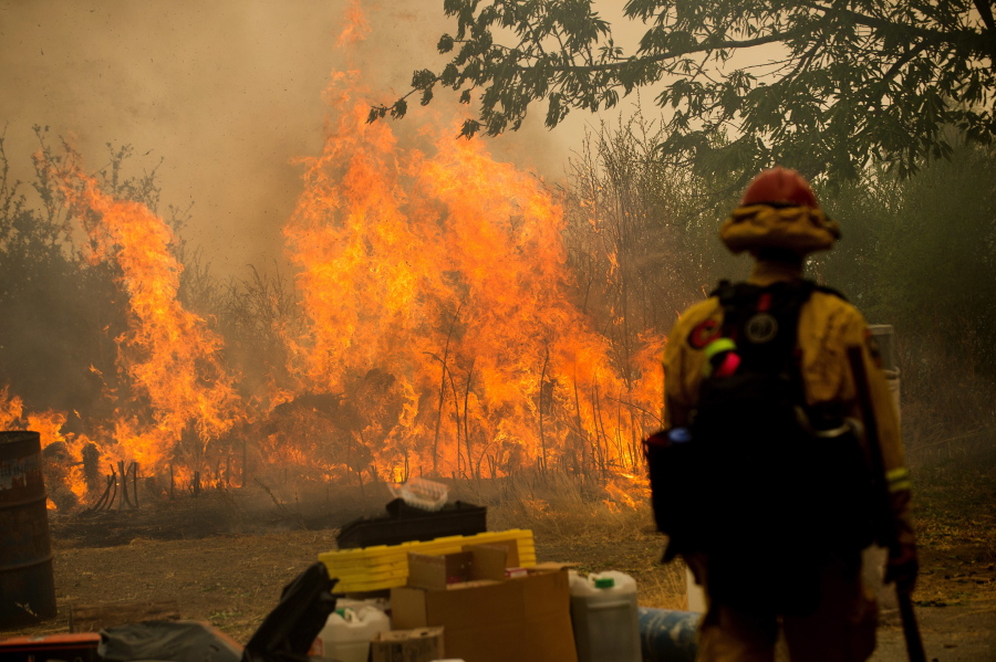 A firefighter watches flames from the Loma fire burn near Morgan Hill, Calif., on Sept. 27.
