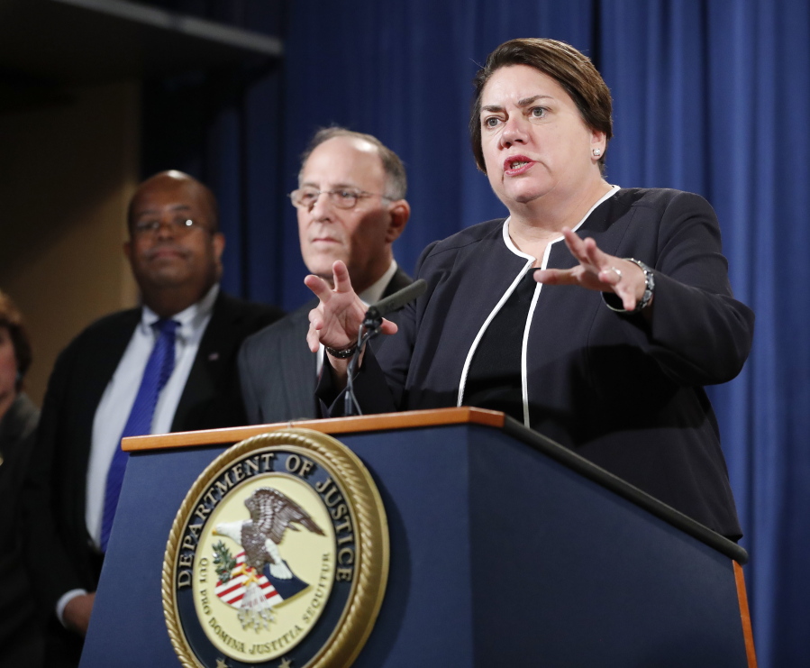 Assistant Attorney General Leslie R. Caldwell, right, of the Criminal Division, with Kenneth Magidson, center, of the Southern District of Texas; and U.S. Treasury Inspector General for Tax Administration J. Russell George, participate in a news conference at the Justice Department in Washington on Thursday. Justice Department is announcing charges in connection with a call center operation said to be based in India. Federal prosecutors have unsealed an indictment charging 61 defendants in the United States and abroad, including five call center groups. The department says the extorted funds ended up being laundered with the help of prepaid debit cards. Arrests are taking place throughout the United States.