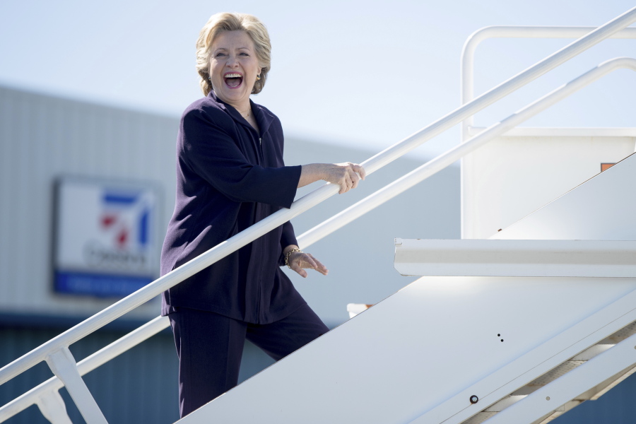 Democratic presidential candidate Hillary Clinton laughs as she answers a reporters question while boarding her campaign plane in White Plains, N.Y., on Monday to travel to Detroit.