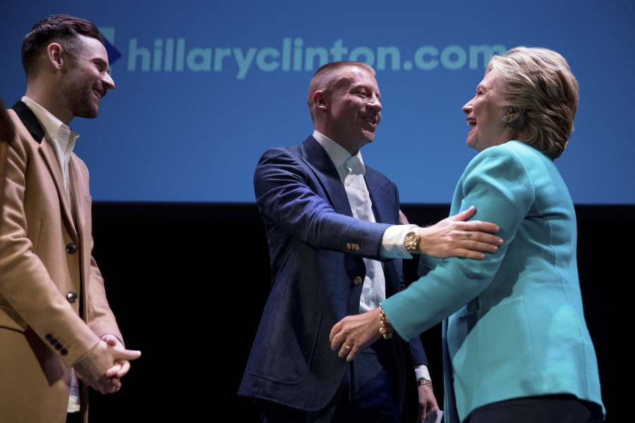Performers Ryan Lewis, left, and Macklemore, center, greet Democratic presidential candidate Hillary Clinton as she takes the stage to speak at a fundraiser Friday at the Paramount Theatre in Seattle.