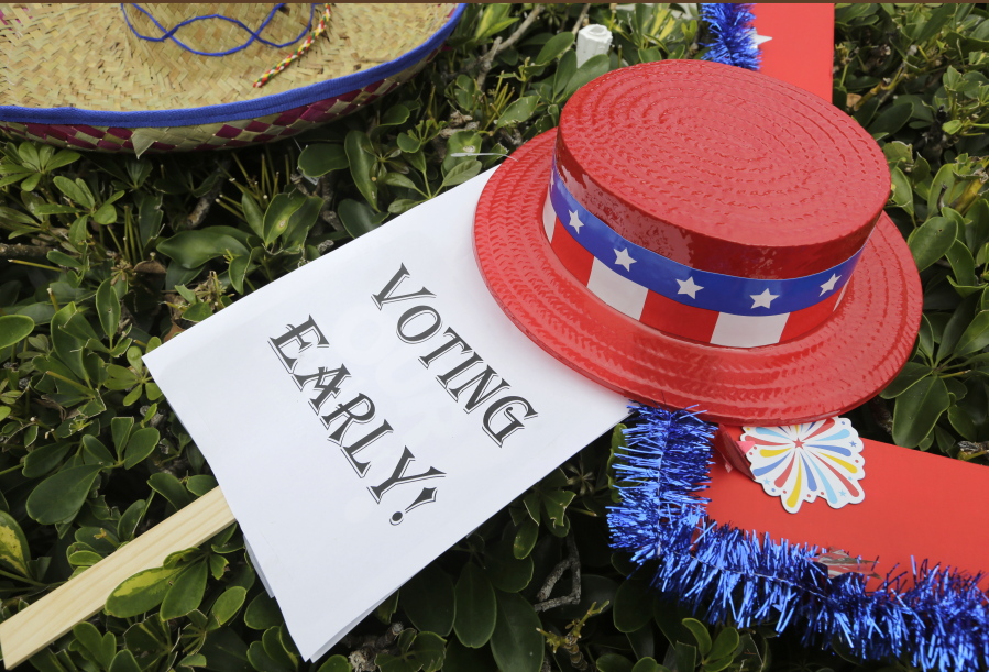 An early voting sign is placed on the grass at an early voting celebration outside of Jackson Memorial Hospital, on the first day of early voting in Miami. The millions of votes that have been cast already in the U.S. presidential election point to an advantage for Hillary Clinton in critical battleground states, as well as signs of strength in traditionally Republican territory.