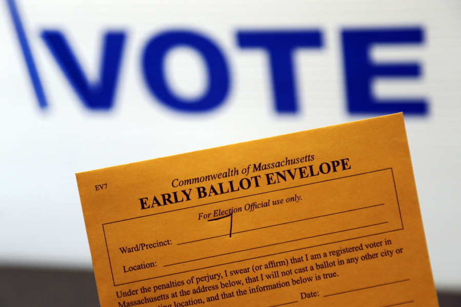 An early ballot envelope is held at town hall in North Andover, Mass.