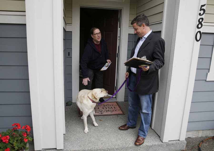 Sen. Mark Mullet, D-Issaquah, right, talks to a voter as he rings doorbells with his dog Arthur in Issaquah, Wash. Mullet is being challenged for his seat in the state legislature by State Rep. Chad Magendanz, R-Issaquah. (AP Photo/Ted S.