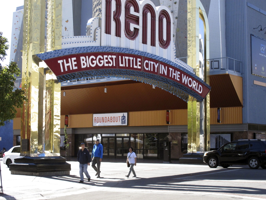 Pedestrians walk Tuesday beneath the famous arch on Virginia Street in downtown Reno, Nev., where a truck plowed into a crowd during a protest Monday evening.