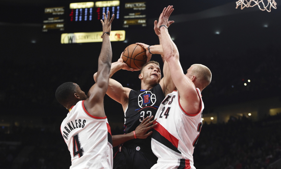 Los Angeles Clippers forward Blake Griffin drives to the basket against Portland Trail Blazers forward Maurice Harkless and forward Mason Plumlee during the first quarter of an NBA basketball game in Portland, Ore., Thursday, Oct. 27, 2016.