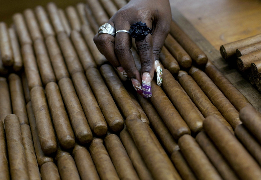 A worker selects cigars March 1, 2013, at the H. Upmann cigar factory, where people can take tours as part of the 15th annual Cigar Festival in Havana, Cuba. The Obama administration announced Friday it is eliminating a $100 limit on the value of Cuban rum and cigars that American travelers can bring back from the island.