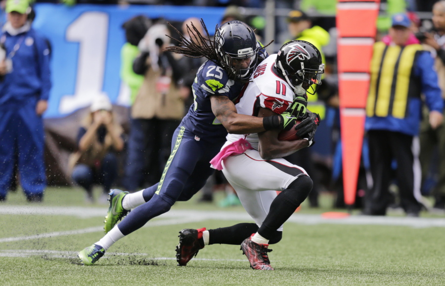 Seattle Seahawks cornerback Richard Sherman (25) tackles Atlanta Falcons wide receiver Julio Jones after Jones made a catch in the first half of an NFL football game, Sunday, Oct. 16, 2016, in Seattle.