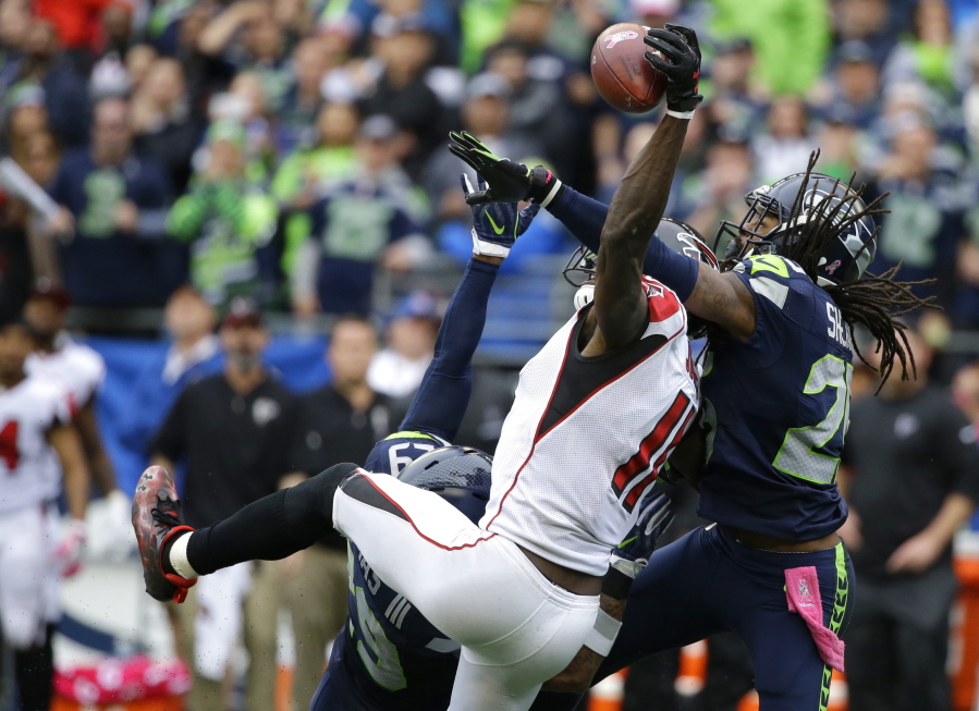 Seattle cornerback Richard Sherman, right, and Earl Thomas break up a pass intended for Atlanta Falcons wide receiver Julio Jones (11) late in the Seahawks&#039; 26-24 win.