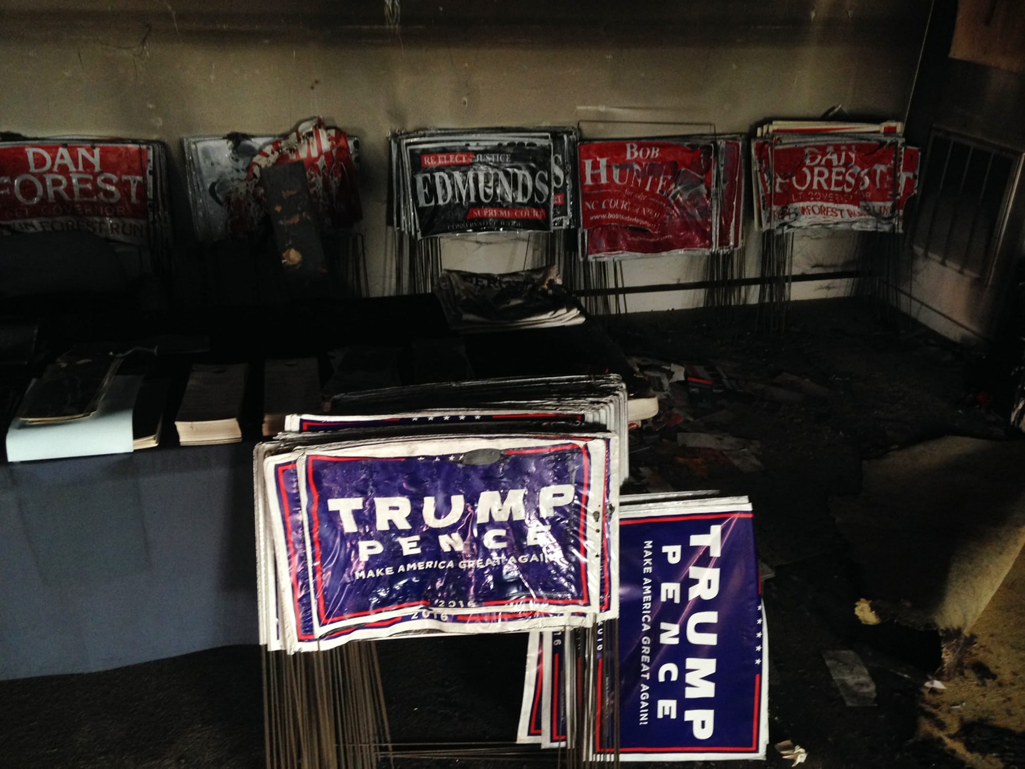 Melted campaign signs are seen at the Orange County Republican Headquarters in Hillsborough, NC on Sunday, Oct. 16, 2016.  Someone threw flammable liquid inside a bottle through a window overnight and someone spray-painted an anti-GOP slogan referring to "Nazi Republicans" on a nearby wall, authorities said Sunday. State GOP director Dallas Woodhouse said no one was injured.