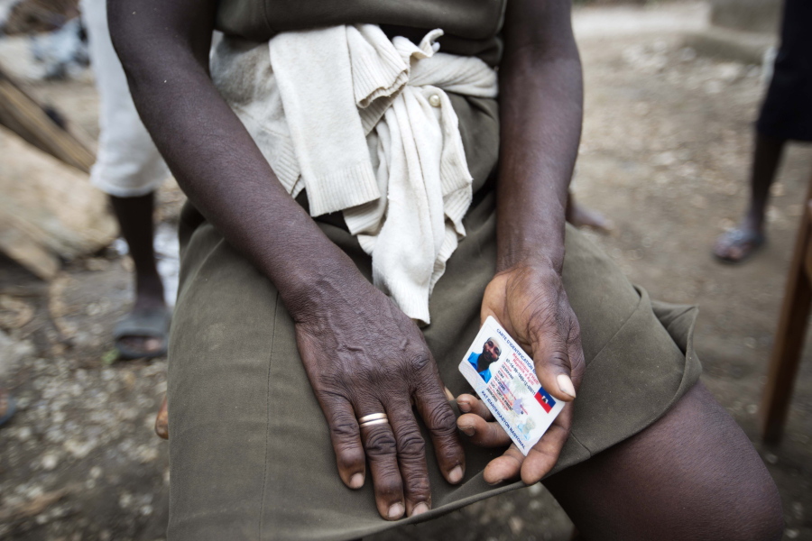 Bertha Mesilier holds the national identification card of her missing husband Edma Desravine, who was last seen seeking refuge from the heavy rainfall and winds brought by Hurricane Matthew, in Port-a-Piment, a district of Les Cayes, Haiti.
