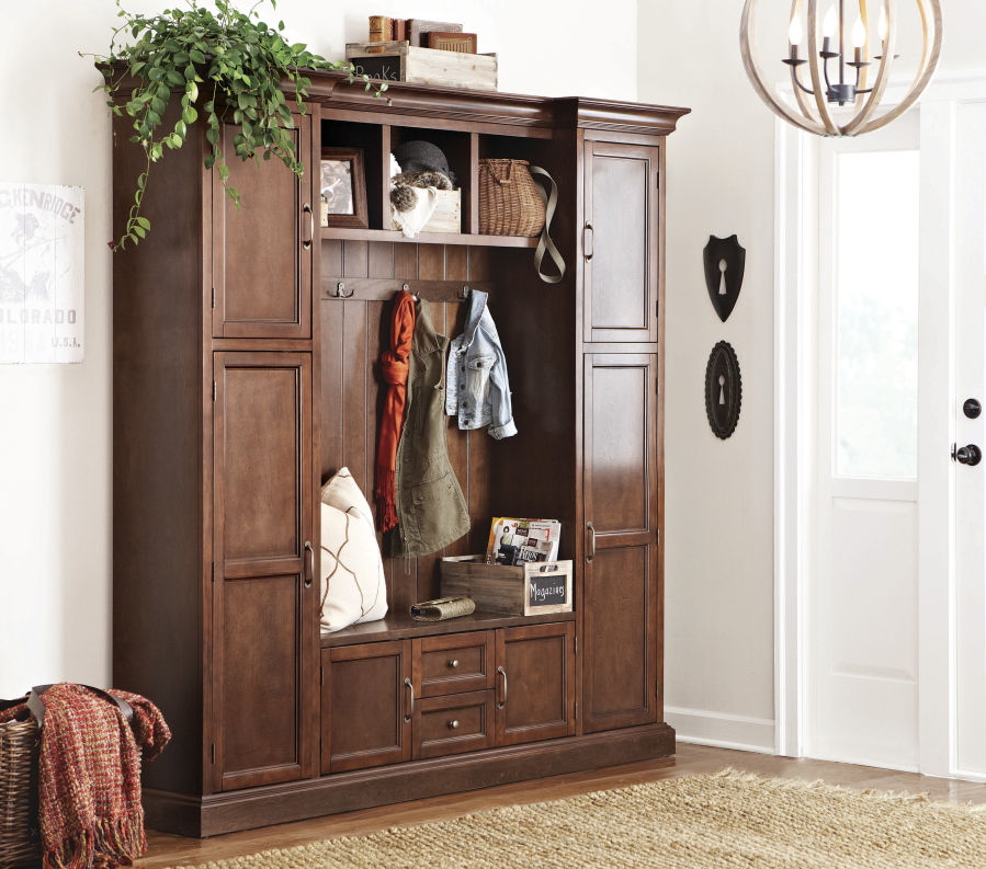 This undated photo provided by The Home Depot shows a cabinet serving as storage in the foyer of a home. One portion of an open foyer can function as a mudroom with help from a cabinet, like the one shown here, that combines closed storage, hanging space, shelving and seating.
