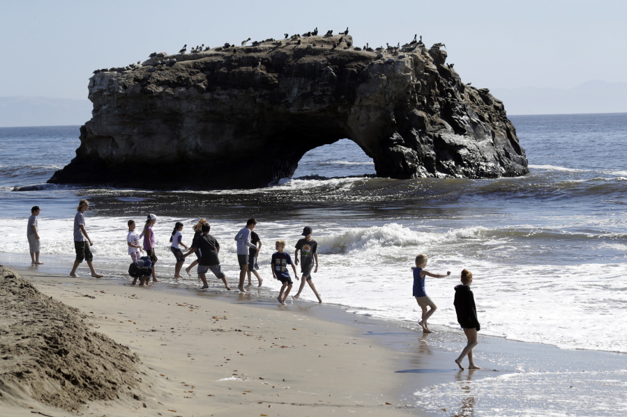 Beachgoers wade in the surf Wednesday at Natural Bridges State Beach in Santa Cruz, Calif. Much of the state, including the San Francisco Bay Area and the Central Valley, had above-normal temperatures.