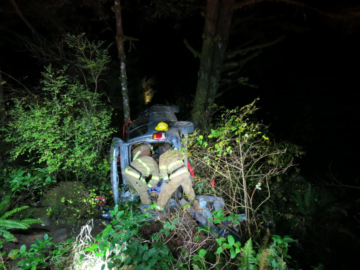 Firefighters work to remove the occupant of a vehicle that went over an embankment near Moulton Falls Park on Saturday night.