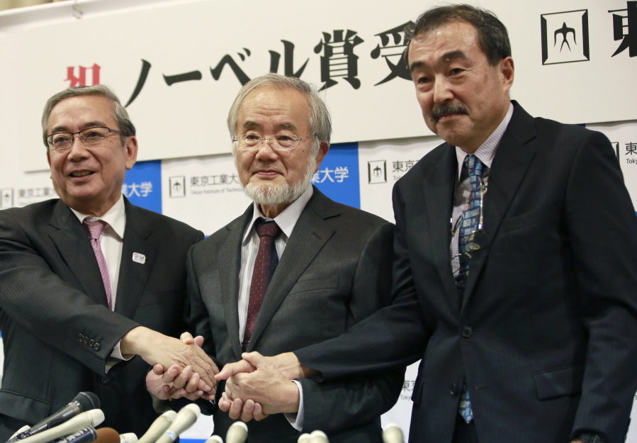 Nobel Prize winner Yoshinori Ohsumi, center, poses with Tokyo Institute of Technology President Yoshinao Mishima, left, and its Excutive Vice President Makoto Ando after a press conference at the Tokyo Institute of Technology in Tokyo on Monday. Ohsumi won the Nobel Prize in medicine on Monday for discoveries on how cells break down and recycle content, a garbage disposal system that scientists hope to harness in the fight against cancer, Alzheimer???s and other diseases.