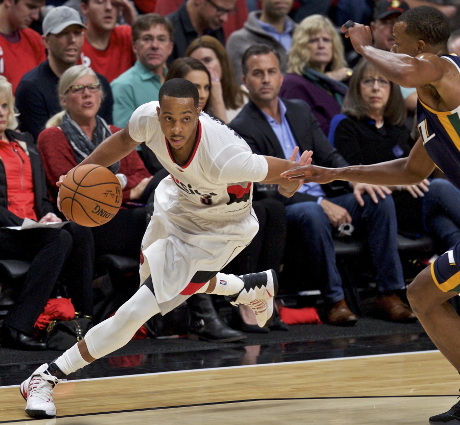 Portland Trail Blazers guard C.J. McCollum, left, dribbles past Utah Jazz guard Rodney Hood, right, during the first half of an NBA basketball game in Portland, Ore., Tuesday, Oct. 25, 2016.