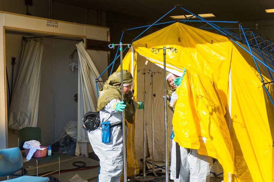 Rachel Marmaud, left, of Emergency Services Associate, and Christa Hughes, an RN of Mosaic, work on cleaning various items inside the decontamination tent at Mosaic Life Care, Friday, Oct. 21, 2016, in Atchison, Kan. At least 85 people sought medical attention after a chemical spill at a distilling plant that released a noxious cloud in northeast Kansas. The Kansas Department of Emergency Management says the cloud occurred Friday morning when two chemicals were mistakenly combined at the MGP Ingredients plant in Atchison. (Dougal Brownlie/The St.