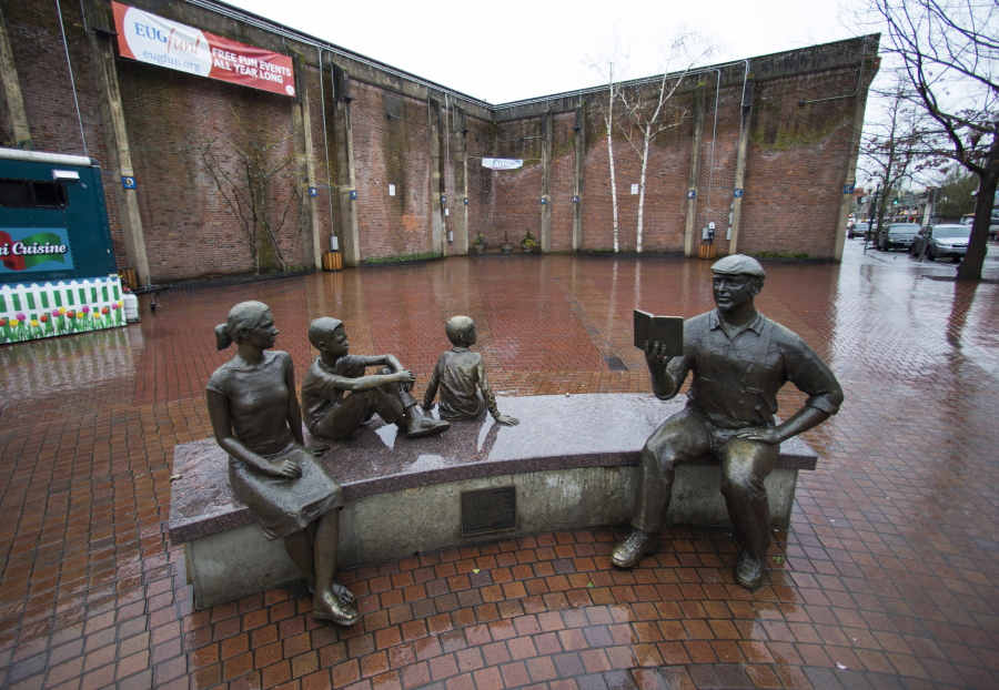 Astatue of novelist Ken Kesey reading to his grandchildren sits in the rain Feb. 26 in Broadway Plaza in Eugene, Ore. A group of Eugene residents wants the public space officially named Kesey Square for the native Oregonian.