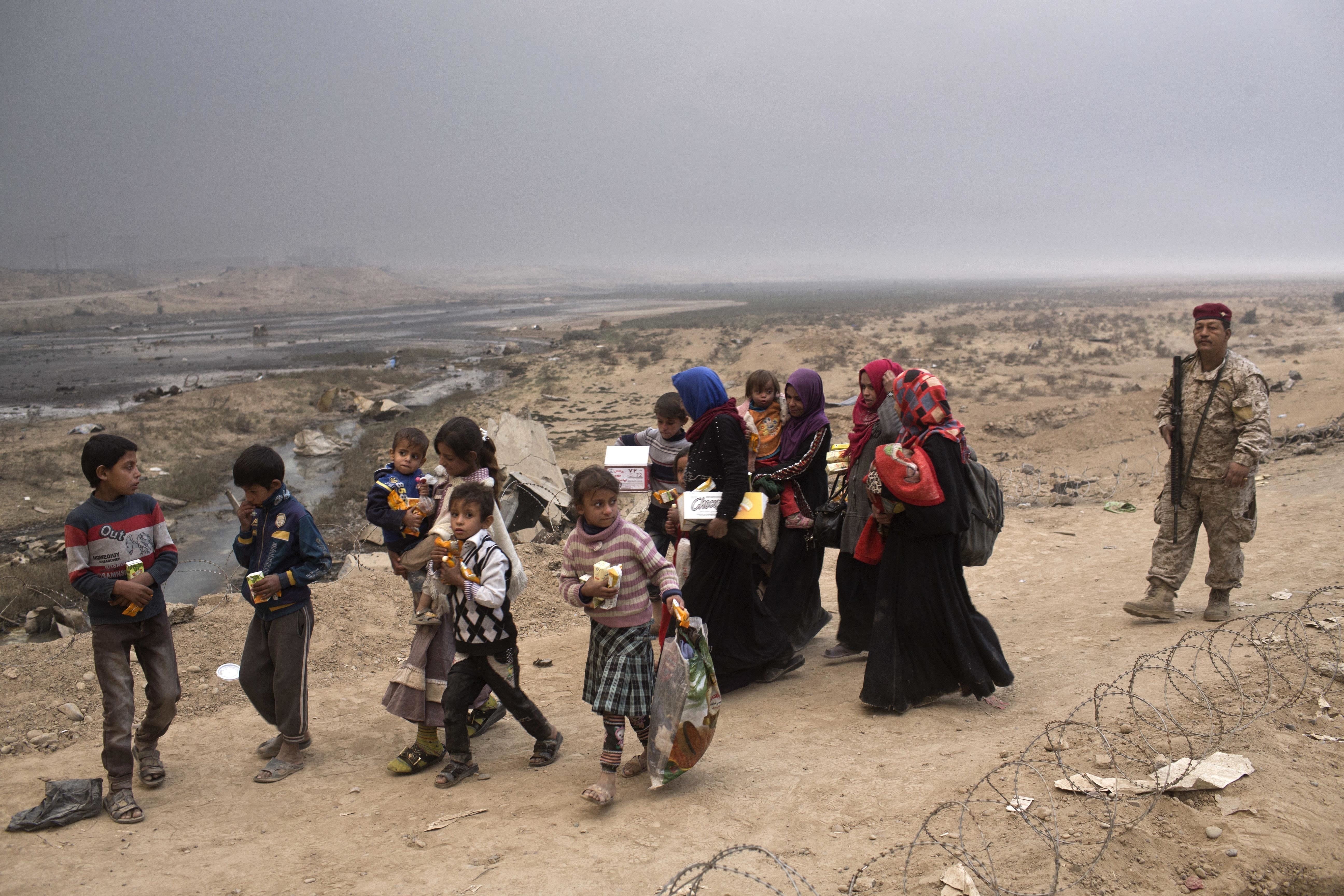 Internally displaced persons clear a checkpoint in Qayara, some 50 kilometers south of Mosul, Iraq, Wednesday, Oct. 26, 2016. Islamic State militants have been going door to door in farming communities south of Mosul, ordering people at gunpoint to follow them north into the city and apparently using them as human shields as they retreat from Iraqi forces. Witnesses to the forced evacuation describe scenes of chaos as hundreds of people were driven north across the Ninevah plains and into the heavily-fortified city, where the extremists are believed to be preparing for a climactic showdown.