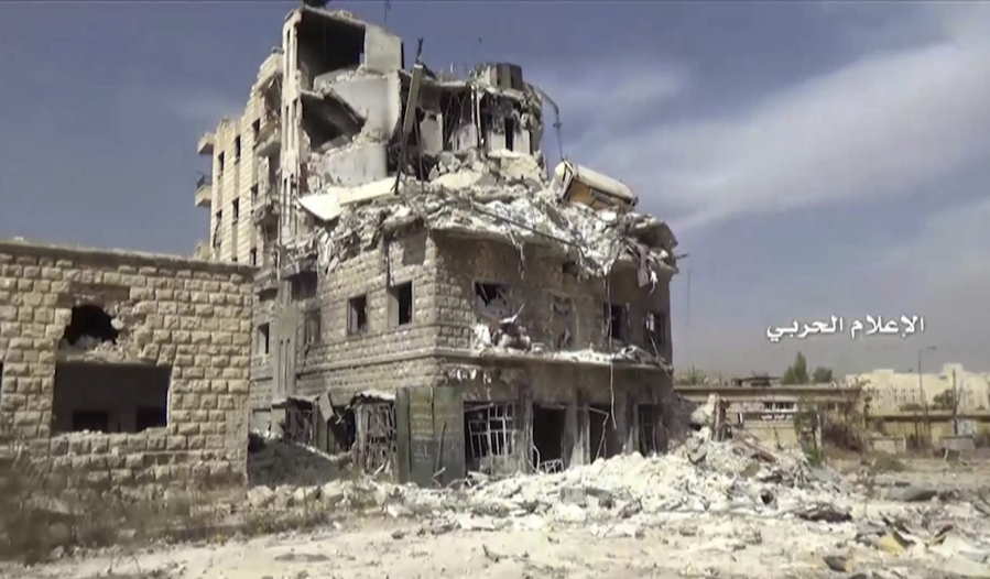 This image from video provided by the Syrian government-controlled Syrian Central Military Media shows damaged buildings Tuesday in Aleppo, Syria.