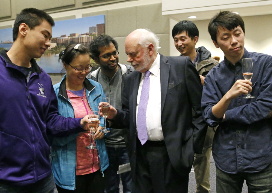 Fraser Stoddart, center, toasts with students Wednesday after a news conference at the Rebecca Crown Center at Northwestern University, in Evanston, Ill. Stoddart, a Scottish-born chemistry professor at Northwestern University, was awarded the Nobel Prize in chemistry on Wednesday. (Nam Y.