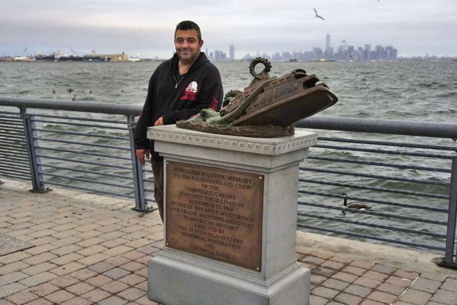Artist Joseph Reginella poses for a photo, in the Staten Island borough of New York, with the cast bronze faux monument dedicated to the memory of the victims of the steam ferry Cornelius G. Kolff.