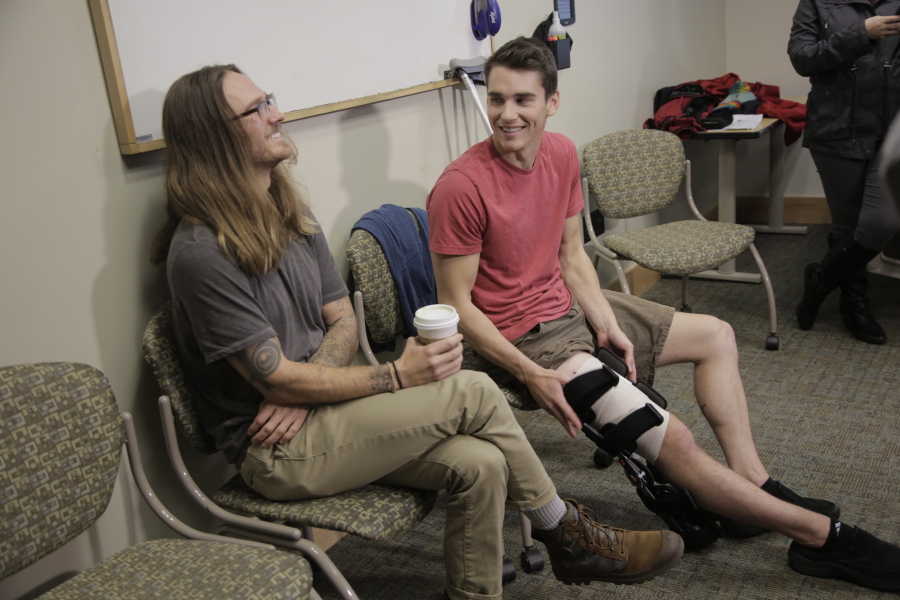 Joseph Tanner, right, survived a shark attack while surfing on the Oregon Coast on Oct. 10. He spoke with media Wednesday at Legacy Emanuel Medical Center in Portland, where he is a critical care nurse. With him is West Woodworth, who helped pull Tanner from the ocean.