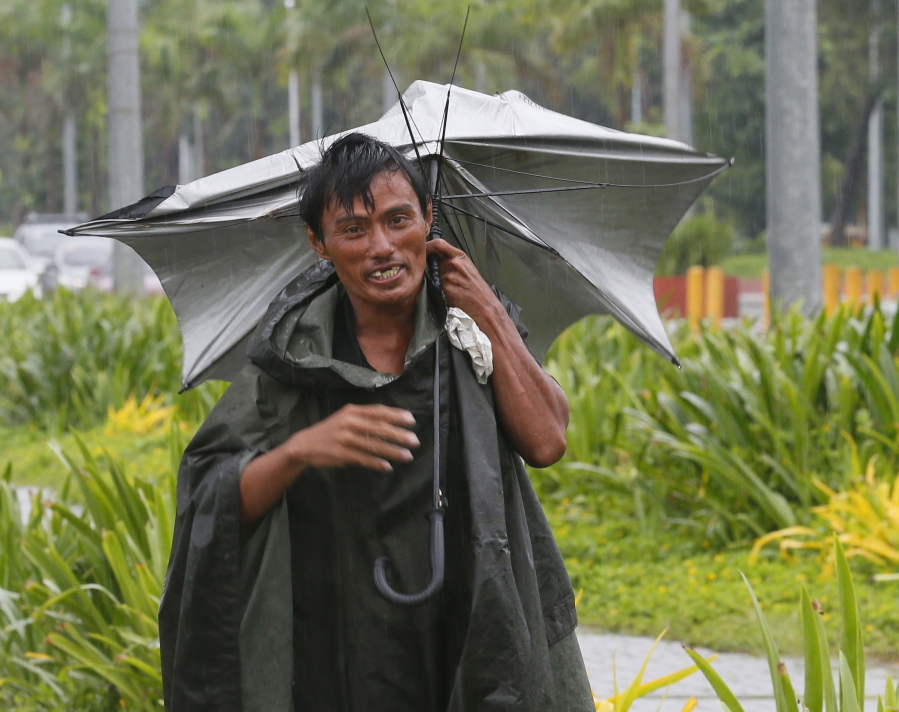 A man walks along a boulevard with an inverted umbrella under a slight rain which was brought about by Typhoon &quot;Karika&quot;  Sunday in Manila, Philippines. The powerful typhoon, with sustained winds of 130 kilometers (80) miles per hour and gusts of 220 kph (136mph), has slammed into the northeastern Philippines and left at least two people dead, knocked out power and isolated villages in floods and toppled trees.