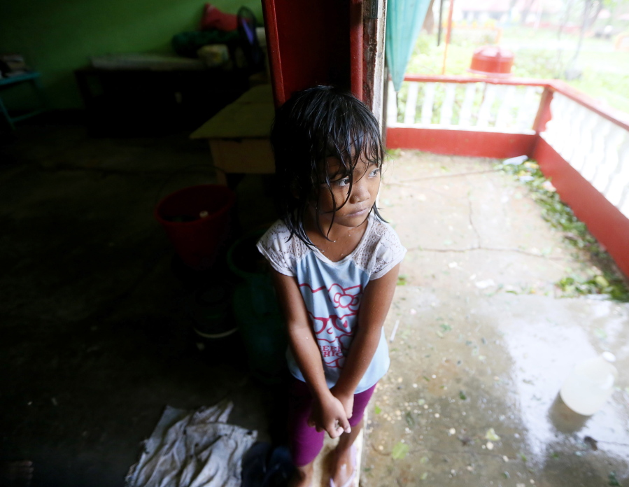 A girl stands by the door of a classroom which serves as her temporary shelter after Super Typhoon Haima destroyed her home at Vigan township, Ilocos Sur province in northern Philippines on Thursday. Super Typhoon Haima slammed into the northeastern Philippine coast late Wednesday with ferocious winds and rain that rekindled fears and memories from the catastrophe wrought by Typhoon Haiyan in 2013.