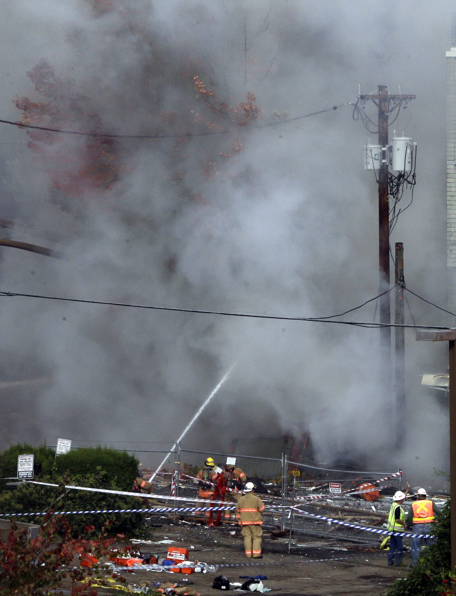 Smoke rises as firefighters battle a blaze after a gas explosion in Portland, Ore., Wednesday, Oct. 19, 2016. A powerful natural gas explosion that neighbors said felt like an earthquake rocked the busy injuring two firefighters and two civilians. One building in the popular shopping district was reduced to rubble and the exterior of one side of another building had been ripped off, its windows blown out.