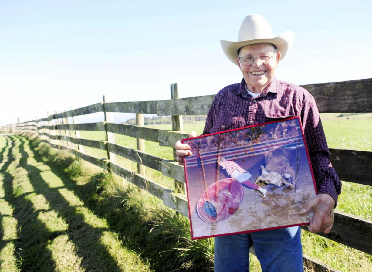 Wick Peth poses for a portrait on his farm in Bow while holding a photo of himself during his bullfighting days, where he is being chased around a rodeo arena by a bull. Peth, 86, will be inducted into the National Cowboy Museum in Oklahoma City.
