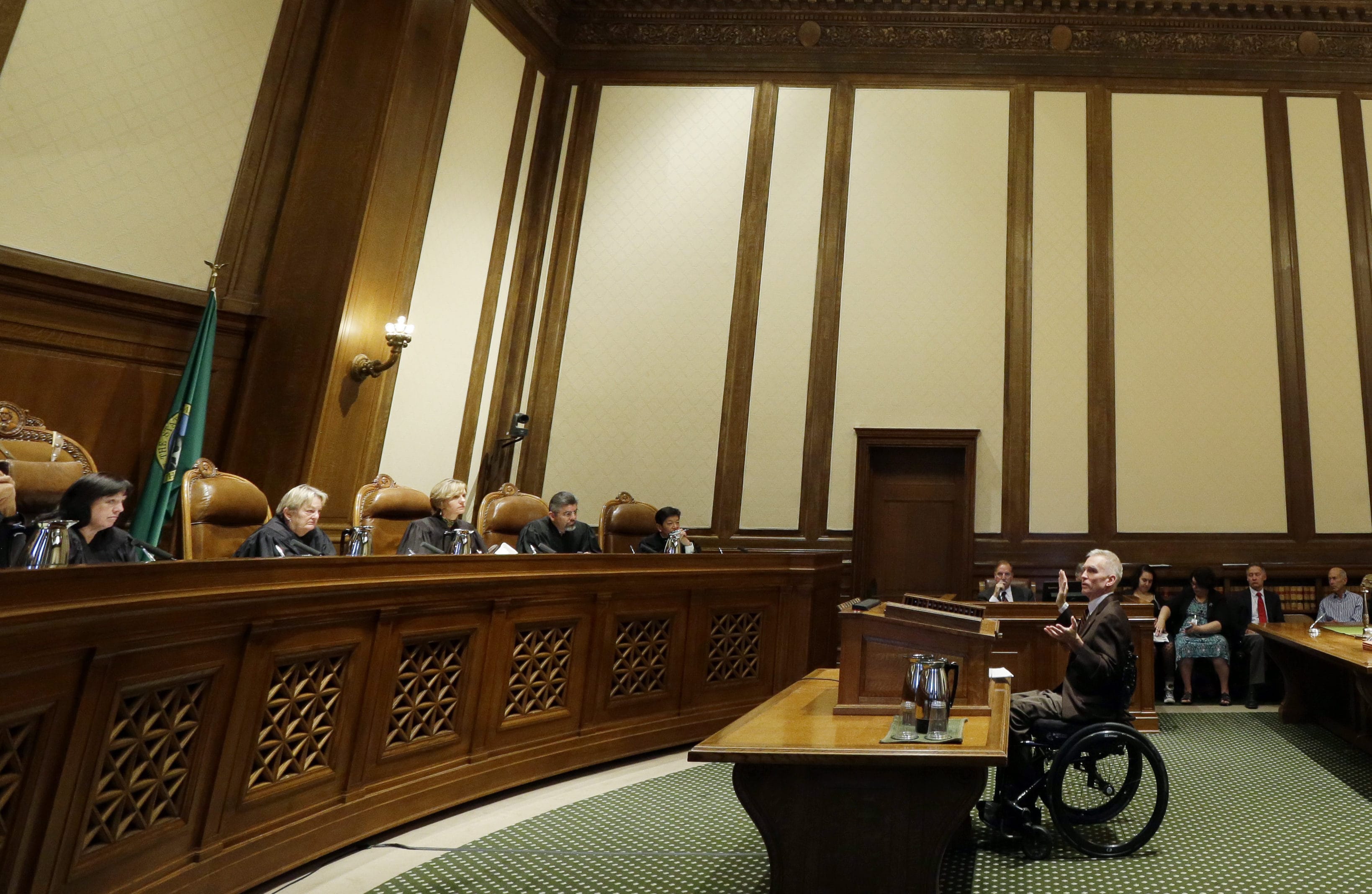 Tom Ahearne, center, the lead attorney in a lawsuit against the state of Washington over education funding, speaks during a hearing before the Washington State Supreme Court, Wednesday, Sept. 7, 2016, in Olympia, Wash. The state wants the court to remove a contempt order and $100,000-a-day sanctions that have been accumulating for more than a year and which are supposed to be set aside into an education account.  (AP Photo/Ted S.