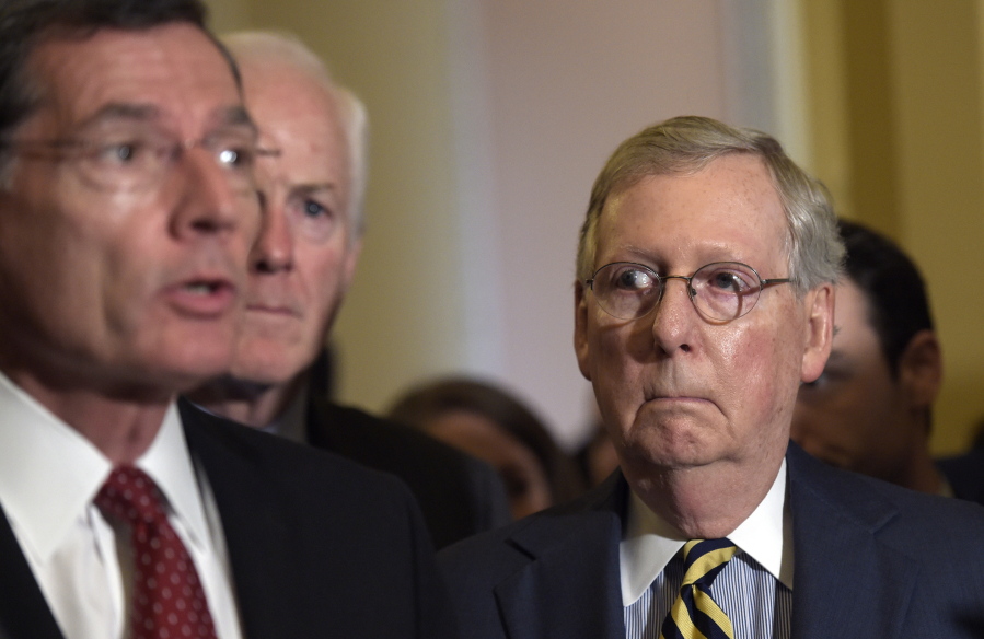 Senate Majority Leader Mitch McConnell of Ky. listens at right as Sen. John Barrasso, R-Wyo., left, speaks during a news conference on Capitol Hill in Washington. Senate Majority Whip John Cornyn of Texas is at center.