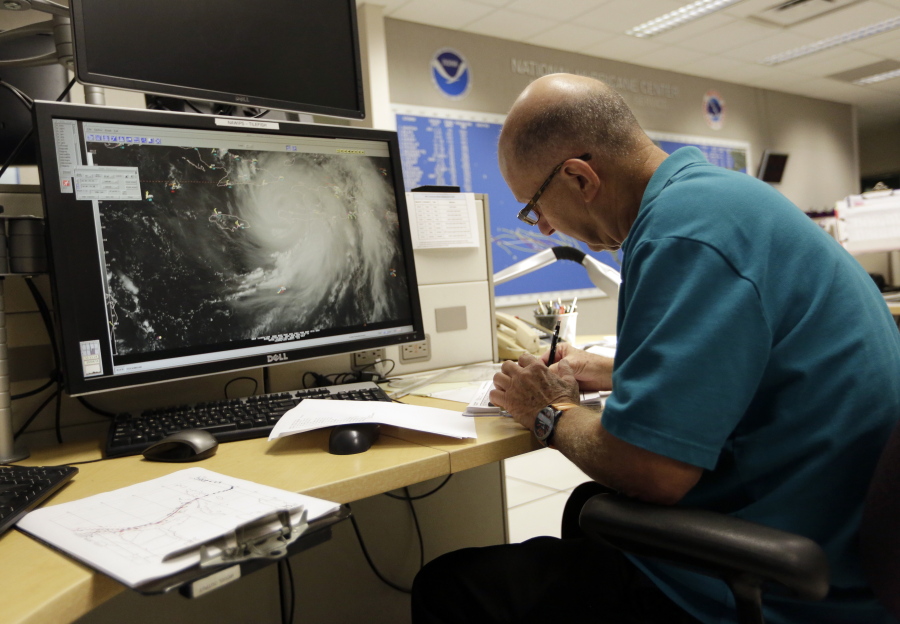 Senior hurricane specialist Lixion Avila monitors the path of Hurricane Matthew at the National Hurricane Center on Tuesday in Miami. Hurricane Matthew roared across the southwestern tip of Haiti with 145 mph winds Tuesday, uprooting trees and tearing roofs from homes in a largely rural corner of the impoverished country as the storm headed north toward Cuba and the east coast of Florida.