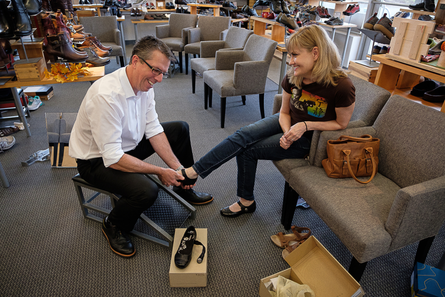 When the Shoe Fits owner Alan O&#039;Hara helps Hollie Olson try on a pair of shoes at his east Vancouver store. Local retailers who have found a successful niche, such as O&#039;Hara, say they are expecting a good holiday shopping season.