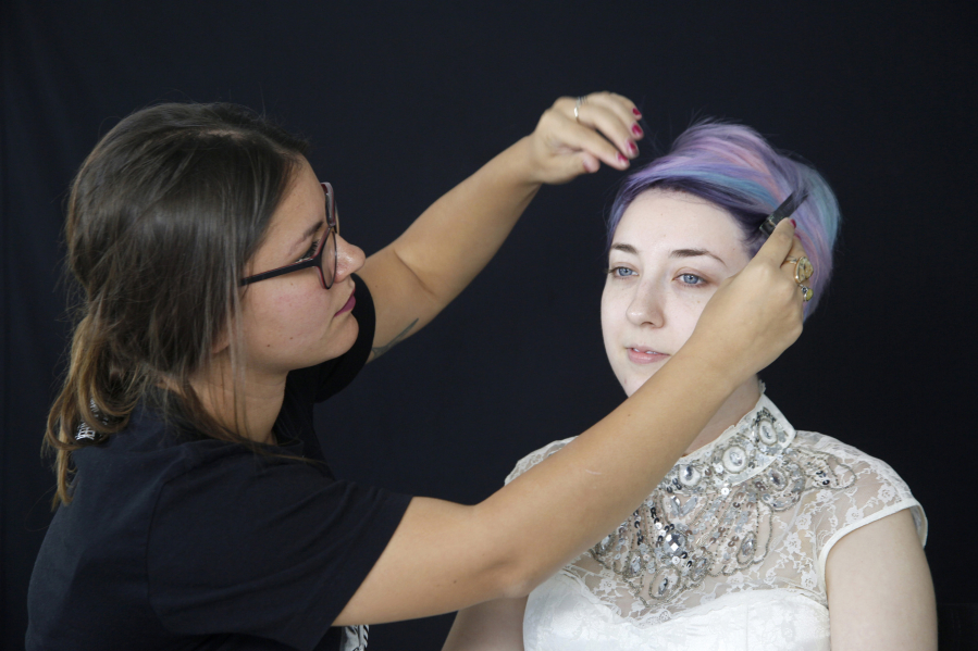 Makeup artist Amber Talarico pins back Kota Wade&#039;s hair.