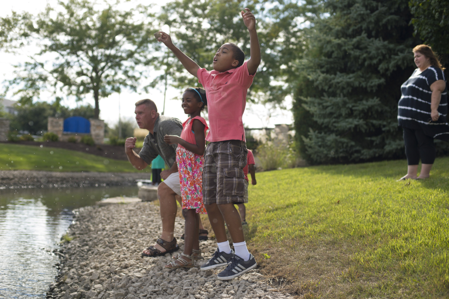 Natalie, 10, and Nicholas, 11, celebrate as their father Ed Pawlinski skips a rock on Sept. 4 in Plainfield, Ill. (Eileen T.