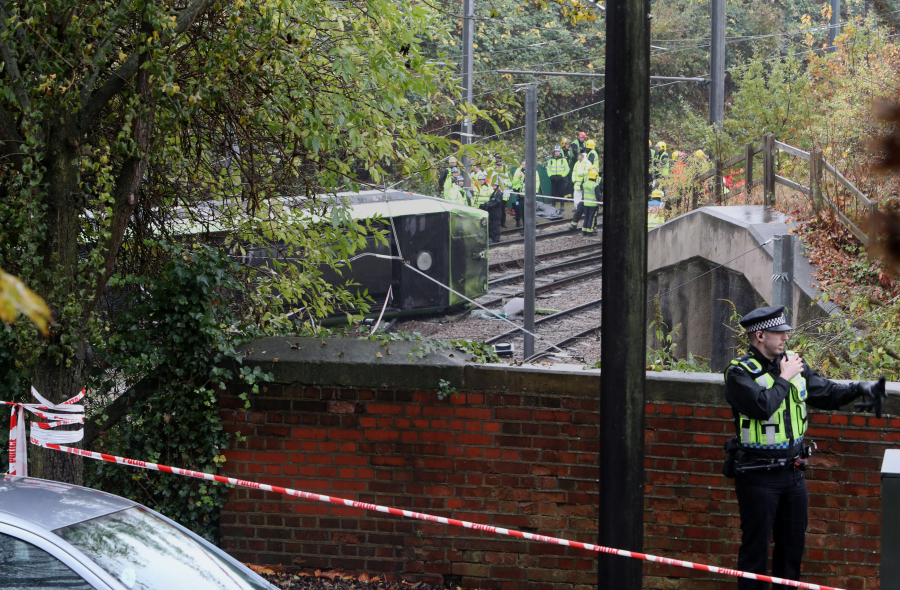 Emergency workers attend the scene of a derailed tram Wednesday morning in Croydon, south London. Seven people were killed and least 50 were injured.