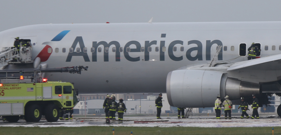 A fire-damaged American Airlines jet is checked over by Chicago firefighters following a blaze on the jet at O&#039;Hare International Airport in Chicago on Oct. 28.