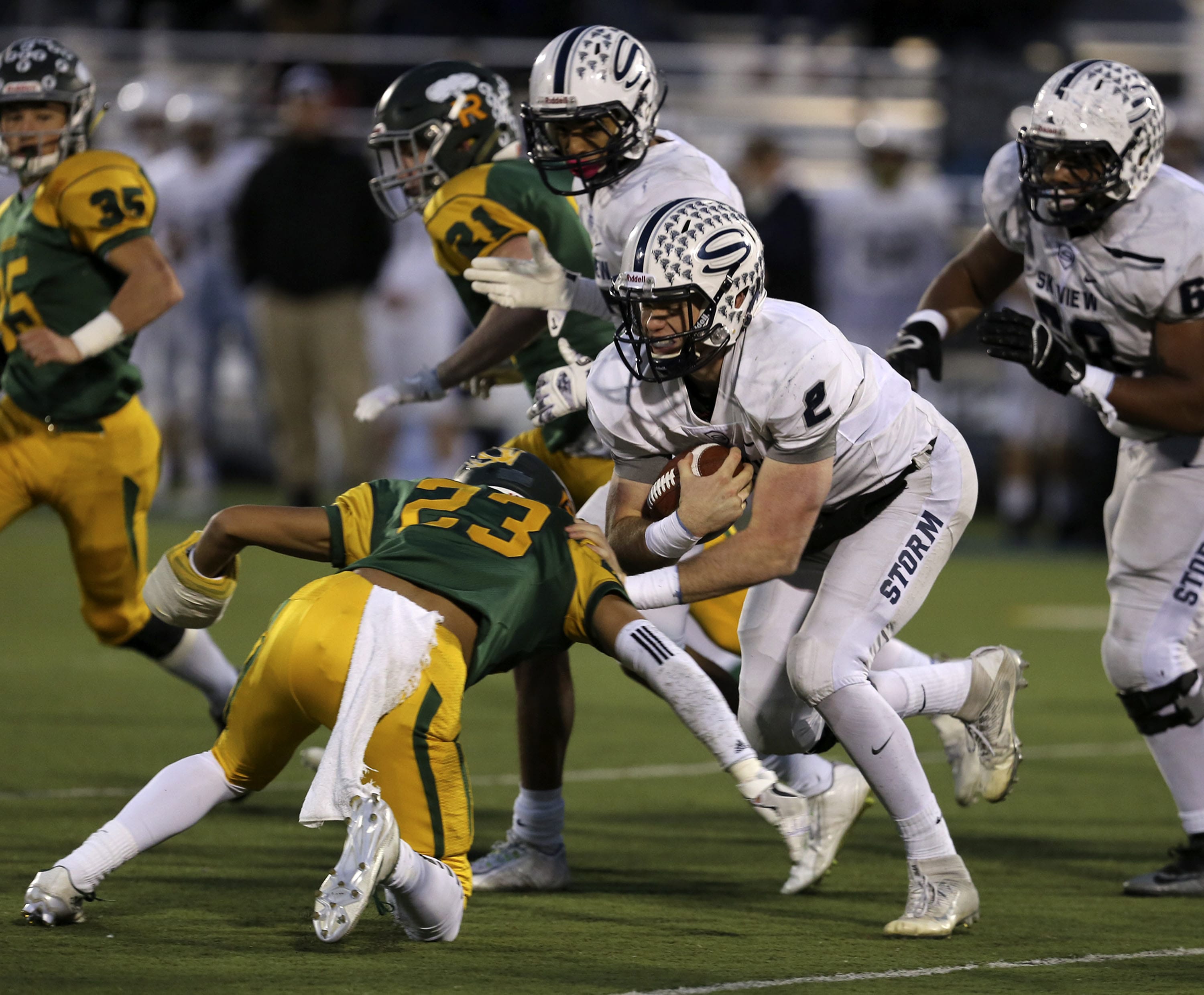 Skyview High School's Brody Barnum (2) is tackled by Richland High School's Josh Mendoza (23) Saturday during the 4A semifinal football game at Neil F.