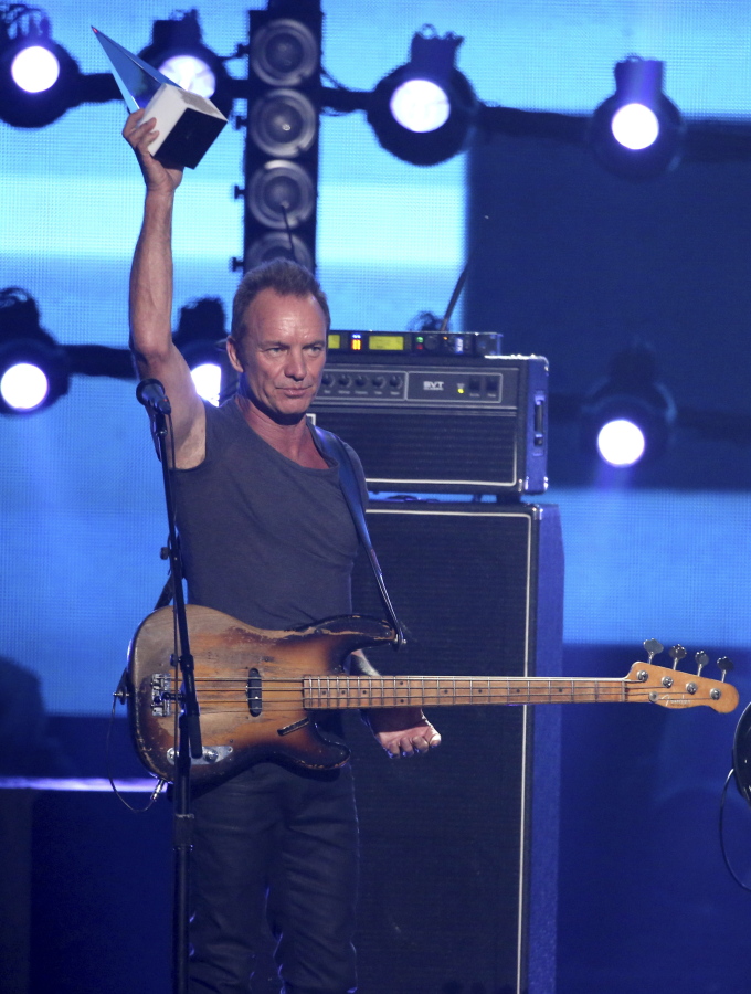 Sting holds the award of merit at the American Music Awards at the Microsoft Theater on Sunday, Nov. 20, 2016, in Los Angeles.
