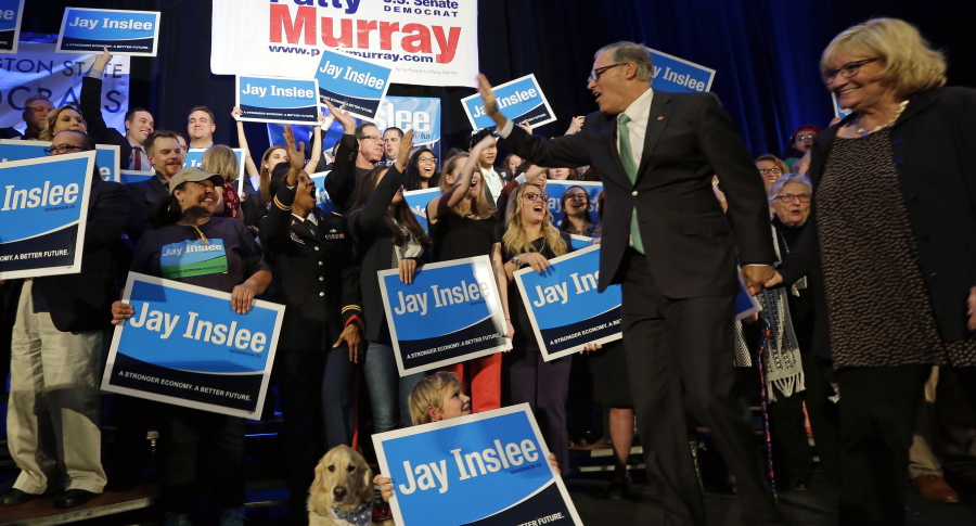 Gov. Jay Inslee waves to supporters as he heads on stage with his wife, Trudi Inslee, at an election night party for Democrats on Tuesday in Seattle.