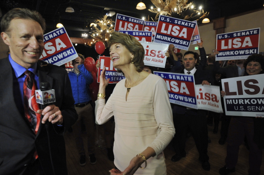 Sen. Lisa Murkowski, R-Alaska, center, reacts to news of her re-election in Anchorage Alaska on Tuesday.